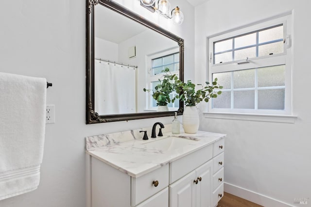 full bathroom with vanity and baseboards