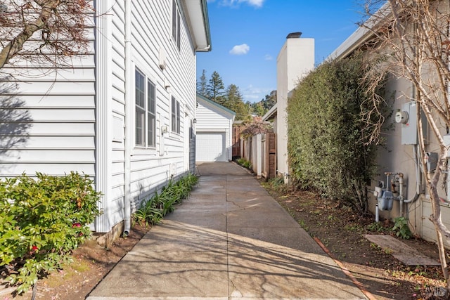 view of property exterior featuring a detached garage and an outdoor structure