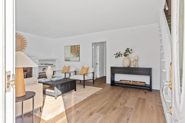 living area with baseboards and wood finished floors