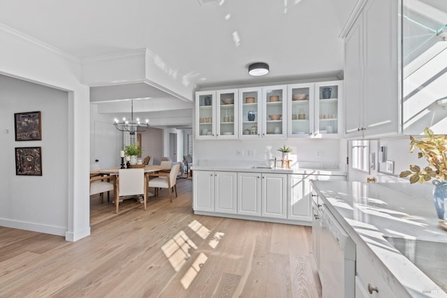 kitchen with light wood-type flooring, white dishwasher, white cabinetry, and ornamental molding