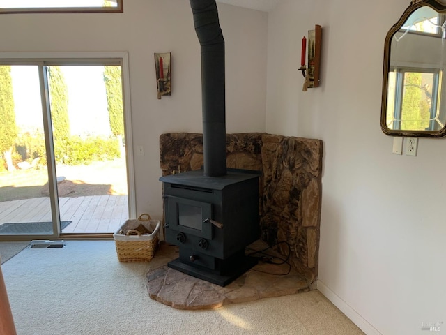 living room with carpet floors and a wood stove