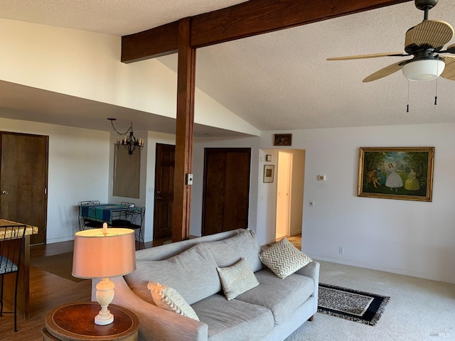 carpeted living room with ceiling fan, lofted ceiling with beams, and a textured ceiling