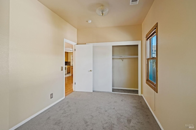 unfurnished bedroom with a closet, baseboards, and carpet