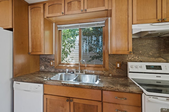 kitchen with decorative backsplash, white appliances, under cabinet range hood, and a sink