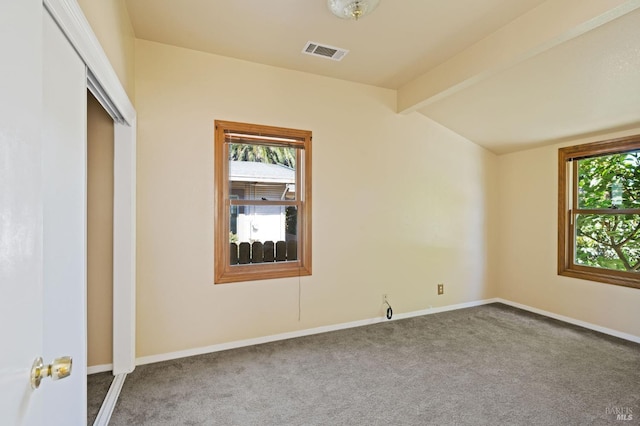 carpeted spare room featuring a wealth of natural light, visible vents, vaulted ceiling with beams, and baseboards