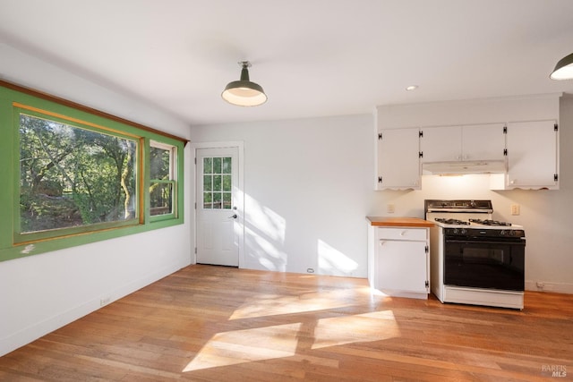 kitchen with white cabinetry, light wood-type flooring, gas range gas stove, and plenty of natural light