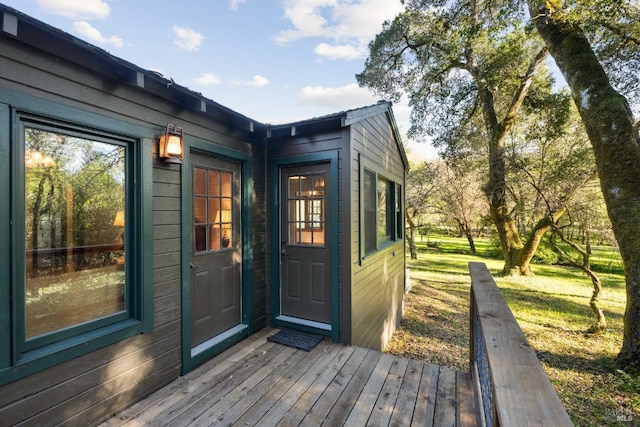 property entrance with a lawn and a wooden deck