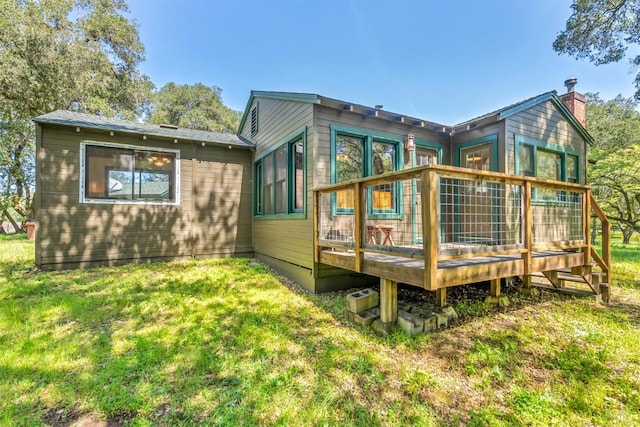 rear view of property featuring a deck and a lawn