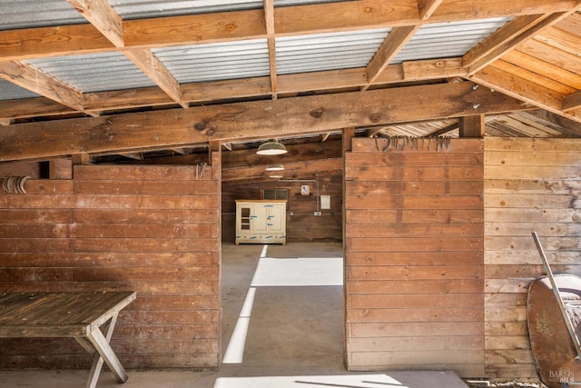 miscellaneous room featuring wood walls and concrete flooring