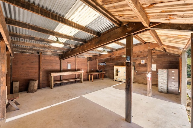 miscellaneous room featuring wooden walls and vaulted ceiling