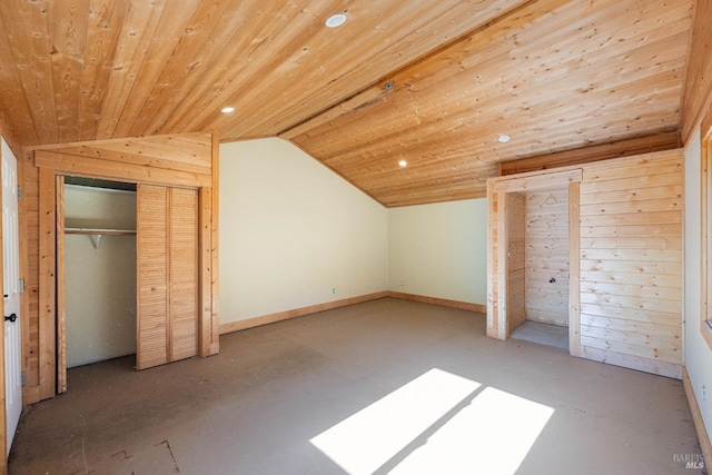 unfurnished bedroom featuring wooden walls, a closet, lofted ceiling, and wood ceiling