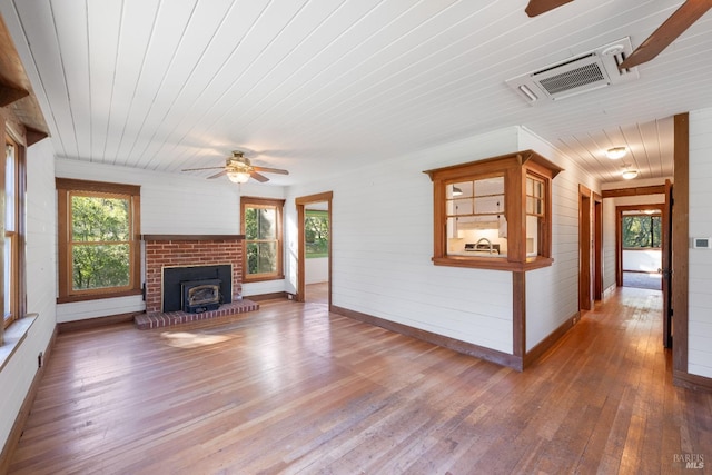 unfurnished living room featuring hardwood / wood-style flooring, ceiling fan, wood walls, and wood ceiling