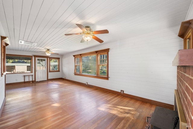 unfurnished living room featuring hardwood / wood-style flooring, ceiling fan, and wood ceiling