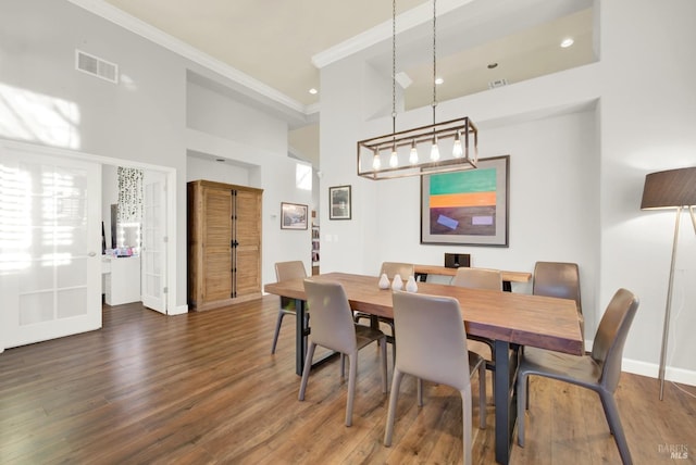 dining room with ornamental molding and dark hardwood / wood-style floors