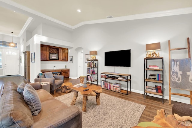 living room with lofted ceiling, hardwood / wood-style floors, and ornamental molding