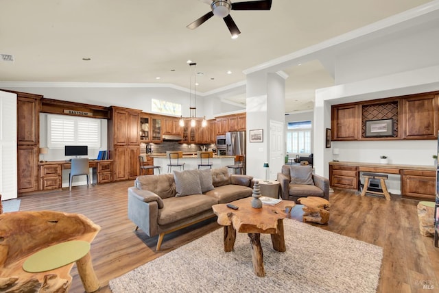 living room featuring hardwood / wood-style flooring, built in desk, ceiling fan, and vaulted ceiling