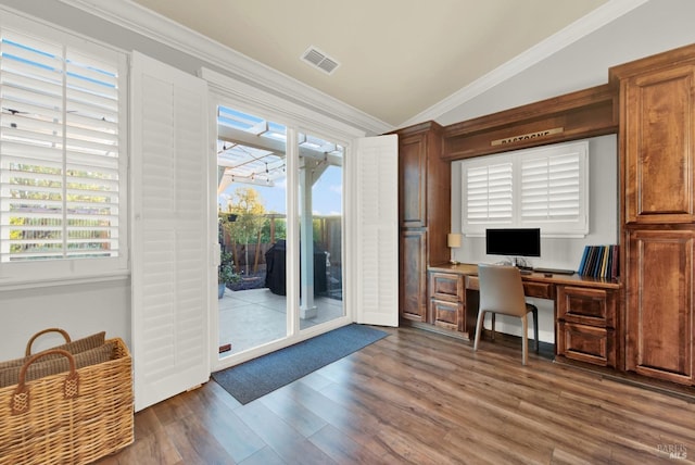 office space with dark hardwood / wood-style flooring, plenty of natural light, ornamental molding, and vaulted ceiling