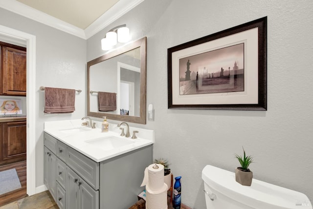 bathroom with ornamental molding, toilet, and vanity