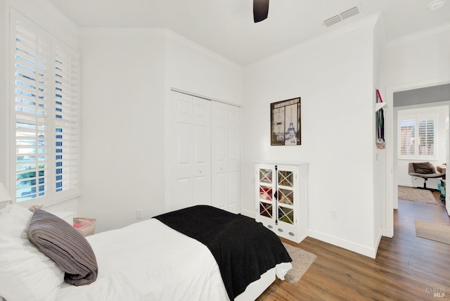 bedroom with multiple windows, crown molding, ceiling fan, and a closet