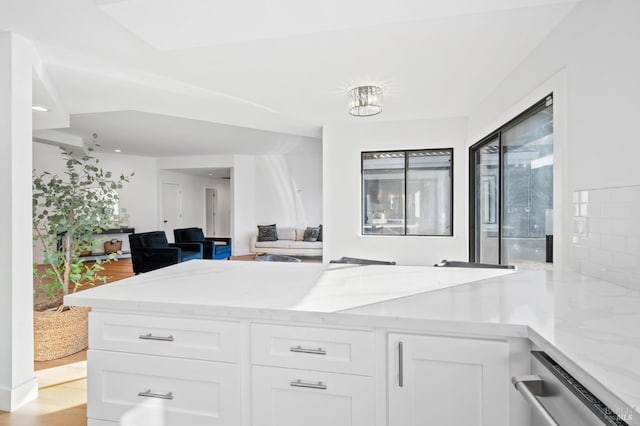 kitchen with white cabinetry, light stone counters, and light hardwood / wood-style flooring