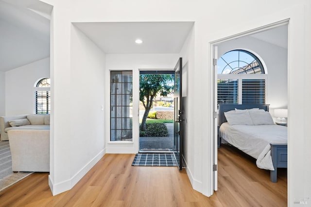 entryway with vaulted ceiling and light hardwood / wood-style floors