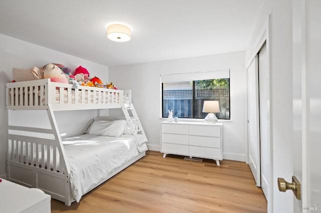 bedroom with light hardwood / wood-style floors and a closet