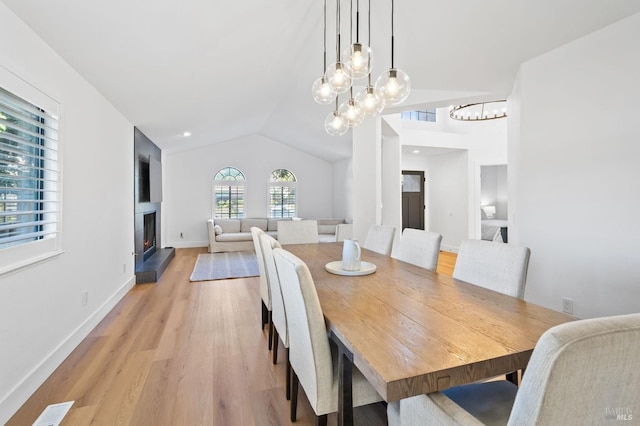 dining room with vaulted ceiling, light hardwood / wood-style flooring, and a notable chandelier