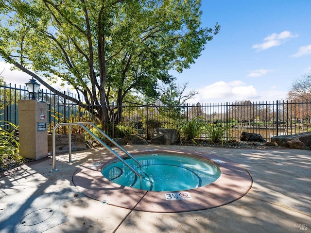 view of swimming pool featuring a hot tub