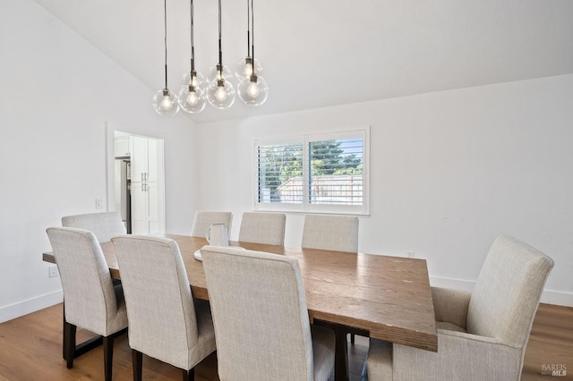 dining space featuring lofted ceiling and light hardwood / wood-style floors