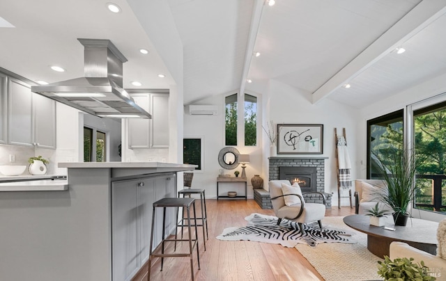 kitchen featuring backsplash, vaulted ceiling with beams, a breakfast bar area, and island range hood