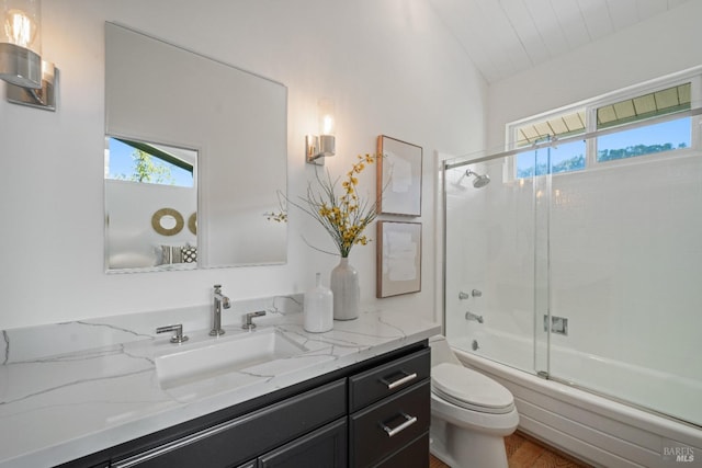 full bathroom featuring hardwood / wood-style floors, shower / bath combination with glass door, vanity, and toilet