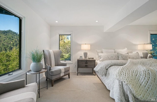 bedroom featuring light colored carpet and multiple windows