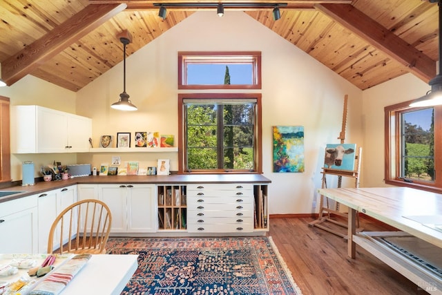 kitchen with wood-type flooring, pendant lighting, high vaulted ceiling, and white cabinetry