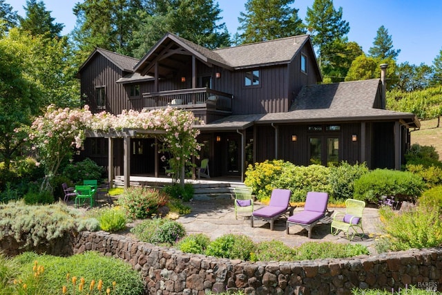 back of house with a balcony, french doors, and a patio