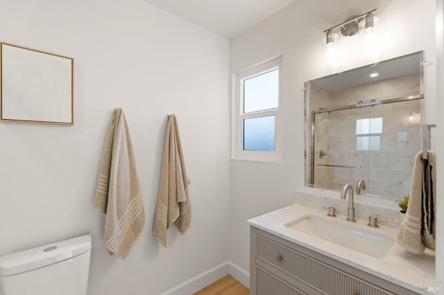 bathroom featuring vanity, toilet, and walk in shower