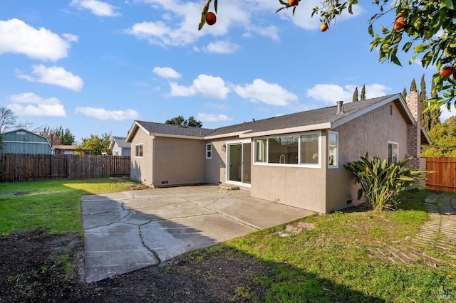 rear view of house with a lawn and a patio area