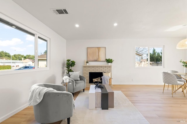 living room with a fireplace and light wood-type flooring