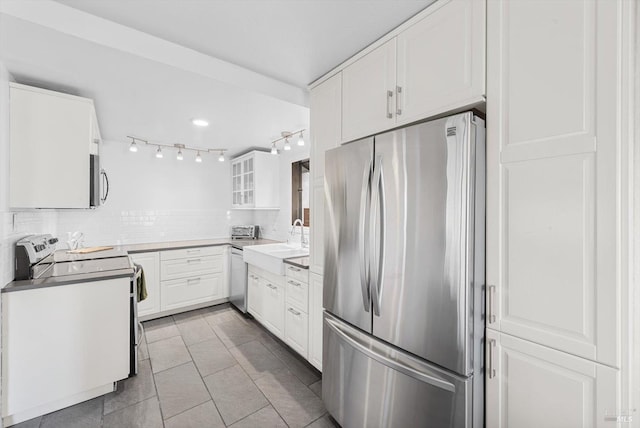 kitchen with tasteful backsplash, sink, white cabinets, and appliances with stainless steel finishes