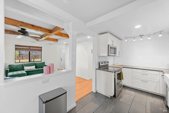 kitchen with white cabinetry, ceiling fan, stainless steel appliances, beam ceiling, and decorative backsplash