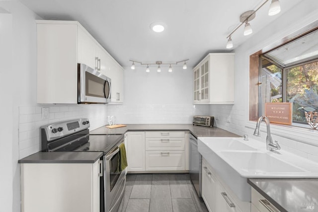 kitchen featuring sink, light tile patterned floors, white cabinetry, stainless steel appliances, and decorative backsplash