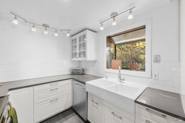 kitchen featuring dishwasher, sink, white cabinets, backsplash, and stove