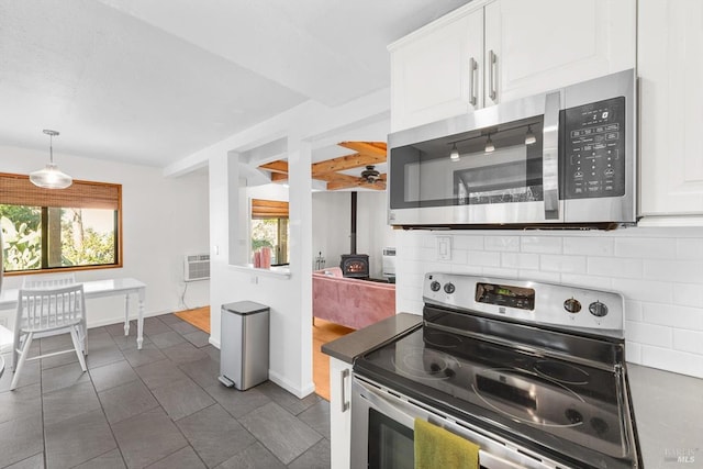 kitchen with white cabinetry, tasteful backsplash, a wall mounted air conditioner, decorative light fixtures, and stainless steel appliances