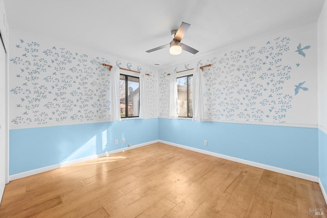 empty room with hardwood / wood-style floors and ceiling fan