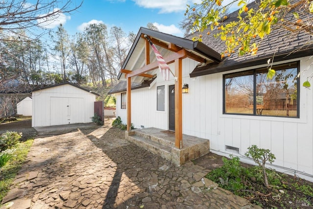 view of side of home featuring a patio area and a storage unit