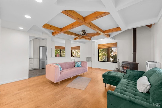 living room featuring coffered ceiling, a wall mounted AC, a wood stove, beam ceiling, and light hardwood / wood-style floors