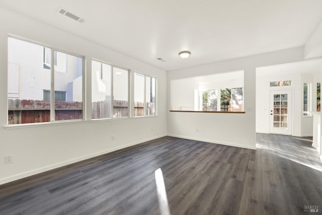 interior space featuring dark wood-type flooring, visible vents, and baseboards