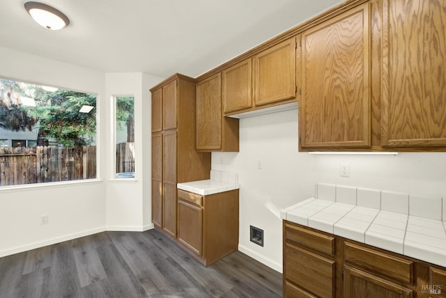 kitchen with tile counters, baseboards, brown cabinetry, and dark wood finished floors