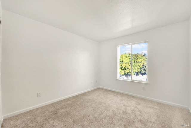 carpeted spare room with baseboards