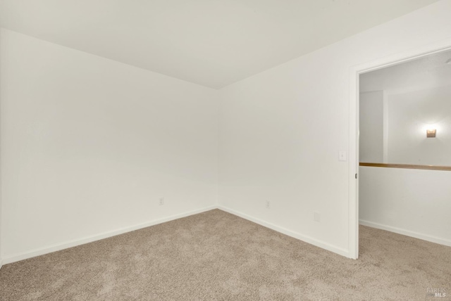 unfurnished room with carpet flooring and baseboards