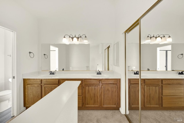 full bath with double vanity, a sink, and toilet